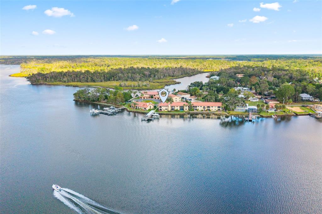 An aerial view shows a waterfront residential complex with boat docks along a river — 371 NW 14TH PLACE, CRYSTAL RIVER, FL