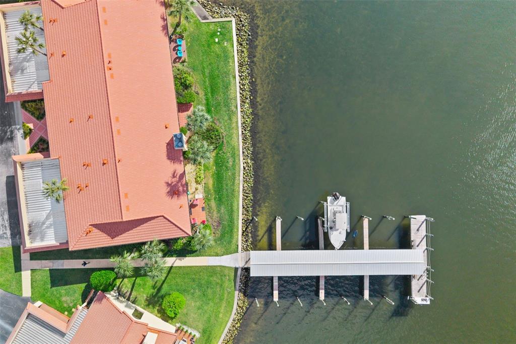 An aerial view shows a waterfront building with a red tile roof and a boat dock — 371 NW 14TH PLACE, CRYSTAL RIVER, FL