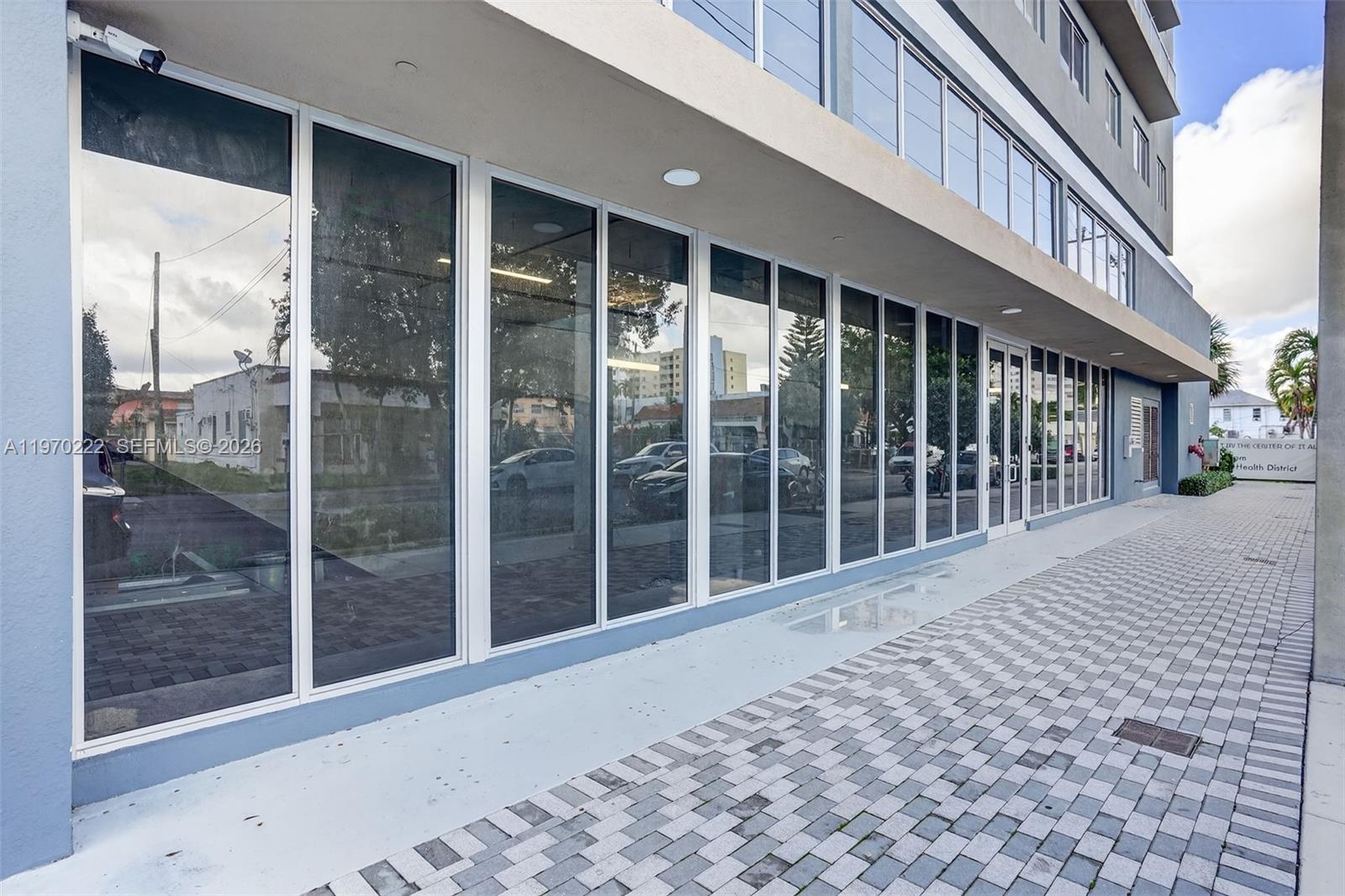 A modern commercial building exterior features a long row of glass storefront windows — 1110 NW 1 ST, Miami FL 33128, MIAMI, FL