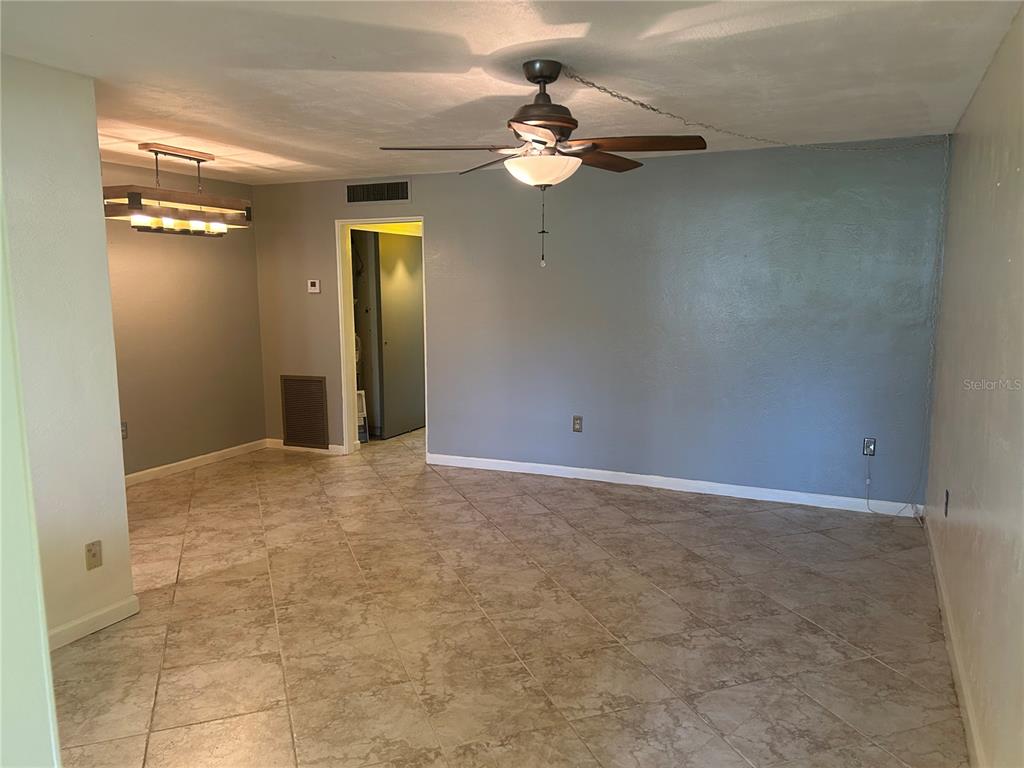 A room with gray walls, tile flooring, a ceiling fan, and a rustic light fixture — 445 32ND AVENUE N UNIT E109, ST PETERSBURG, FL
