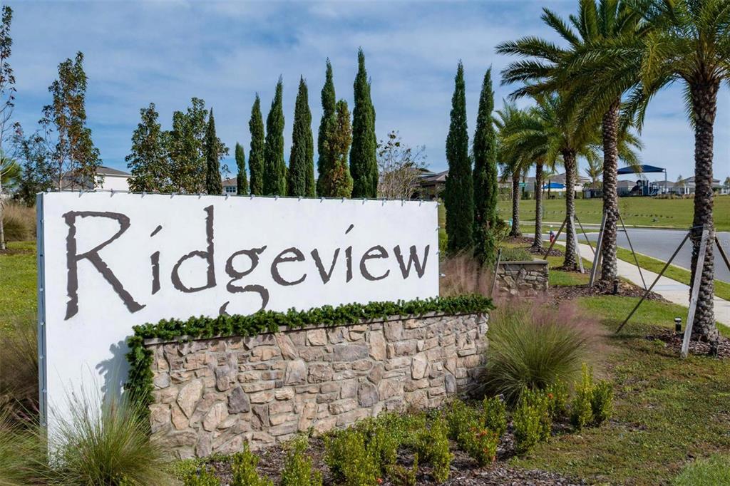 A stone-based sign with the name Ridgeview stands in front of palm trees and landscaping — 14640 CRESTAVISTA DRIVE, CLERMONT, FL