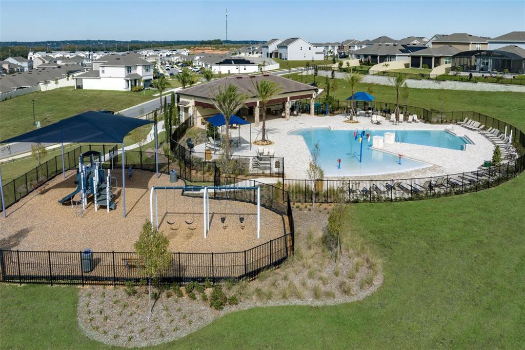 An aerial view shows a community playground and swimming pool area with a covered pavilion — 14640 CRESTAVISTA DRIVE, CLERMONT, FL