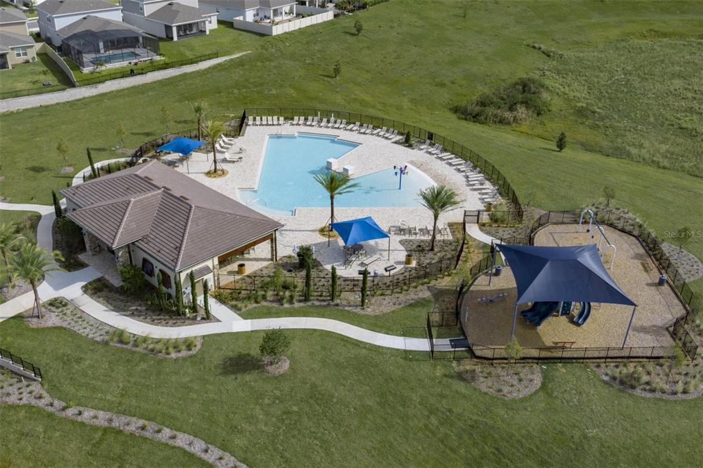 An aerial view shows a community clubhouse with a swimming pool and a playground — 14640 CRESTAVISTA DRIVE, CLERMONT, FL