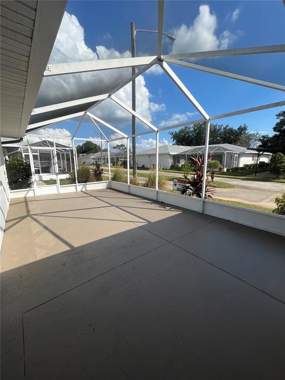 A screened-in patio with a concrete floor and a view of neighboring houses — 1111 APPLE TERRACE, LEESBURG, FL