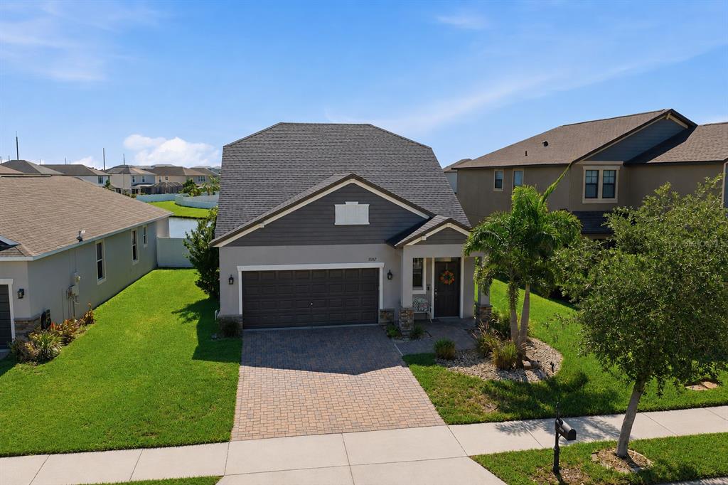 A covered front porch features a stone-based pillar, a bench, and a brown front door — 11767 LAKE BOULEVARD, NEW PORT RICHEY, FL