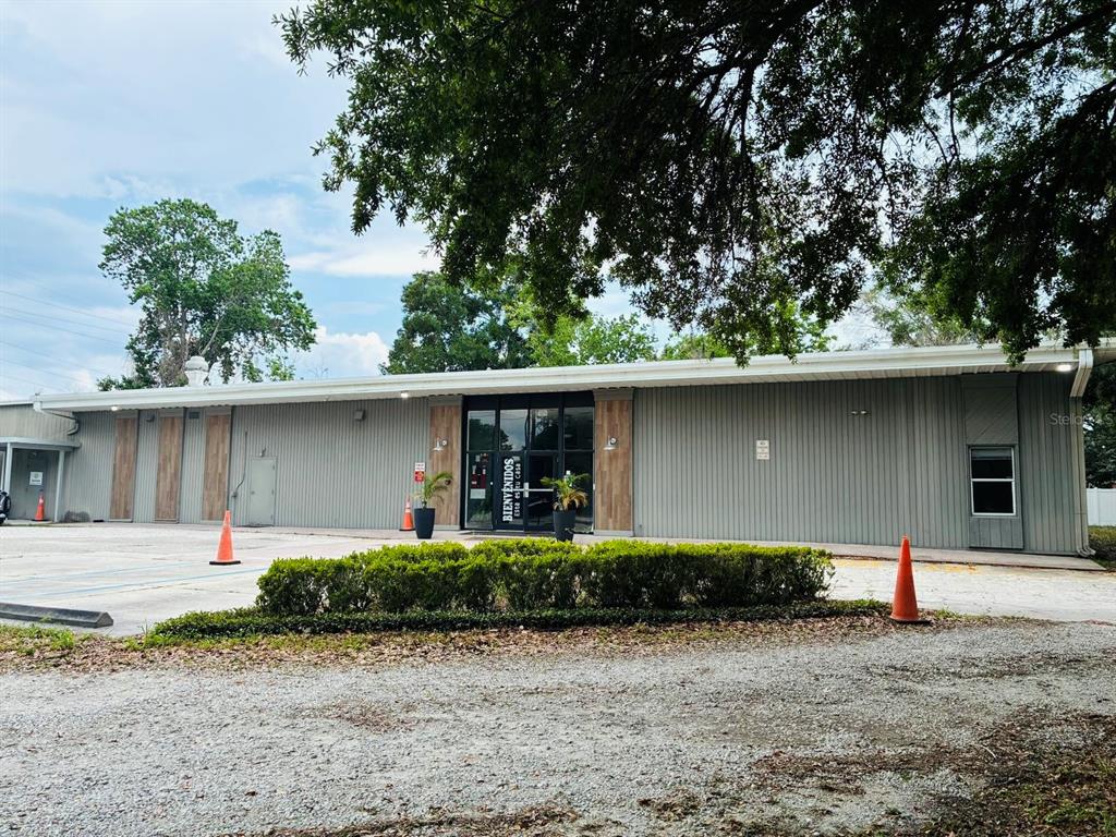 A single-story commercial building with gray metal siding and a central glass entrance — 7540 GRAND AVE, WINTER PARK, FL
