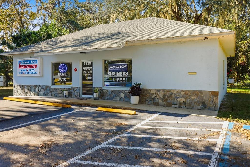 A single-story commercial building with a stone facade, white siding, and a parking lot — 2339 N COUNTY 470 ROAD, LAKE PANASOFFKEE, FL