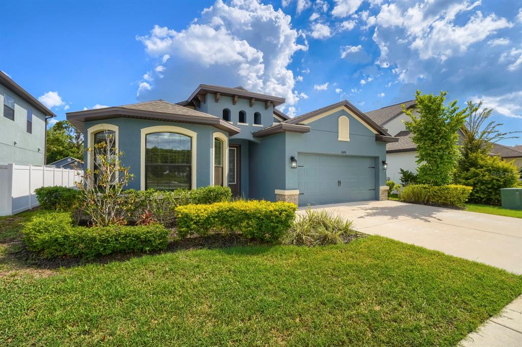 A blue single-story house with a two-car garage and a landscaped front yard — 12690 VANDER WAY, NEW PORT RICHEY, FL