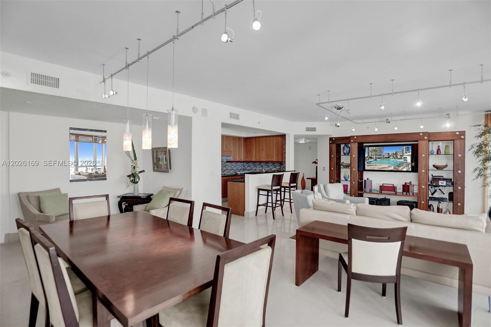 A dining area and living room with a kitchen island and track lighting — 3101 S Ocean Dr, Hollywood FL 33019, HOLLYWOOD, FL