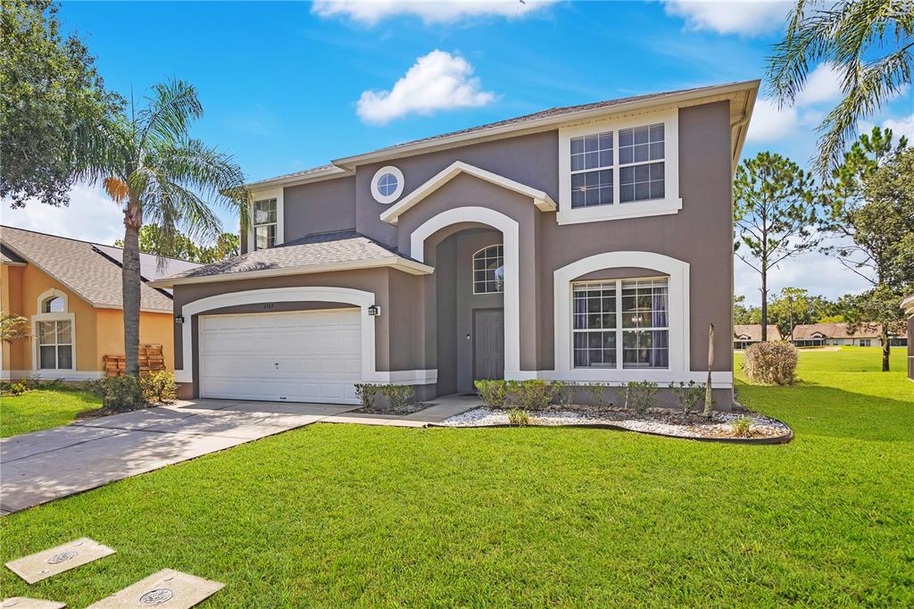 A two-story house with a gray exterior, white trim, and an attached two-car garage — 2765 KOKOMO LOOP, HAINES CITY, FL