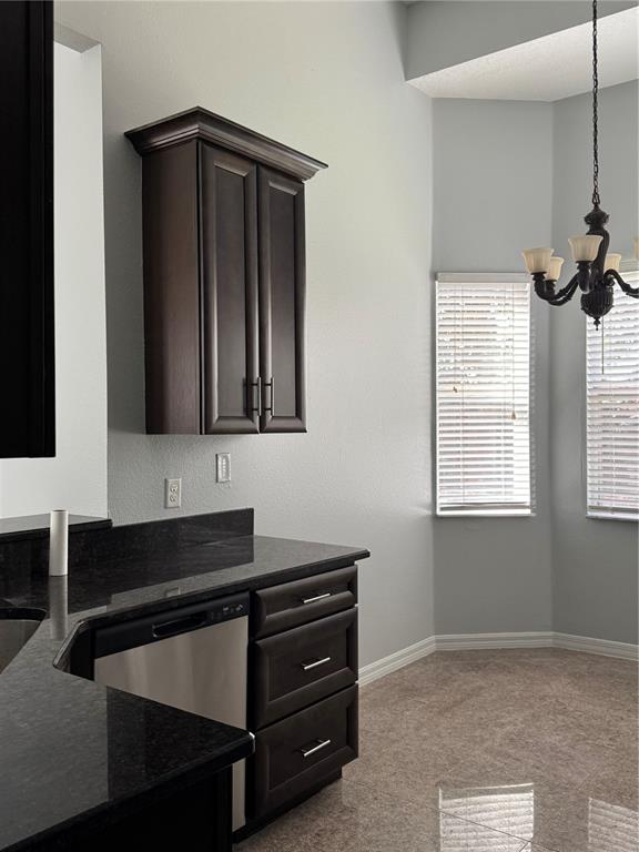 A kitchen area features dark wood cabinets, black granite countertops, and a stainless steel dishwasher — 1767 CAMBRIDGE VILLAGE COURT, OCOEE, FL
