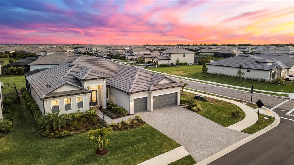 An aerial view of a single-story suburban house with a tiled roof and paved driveway — 15306 GOLDEN BEAM PLACE, BRADENTON, FL
