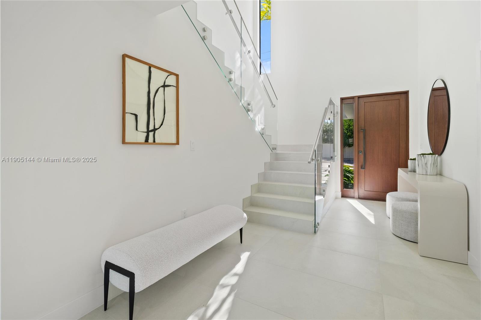 A bright entryway features a white staircase with glass railings, a bench, and a console — 2127 SW 11th Ter, Miami FL 33135, MIAMI, FL