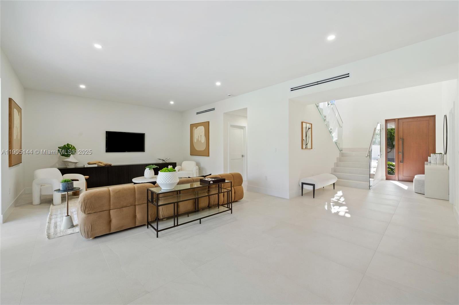 A modern living room features a tan sofa, white chairs, and a staircase with glass railings — 2127 SW 11th Ter, Miami FL 33135, MIAMI, FL