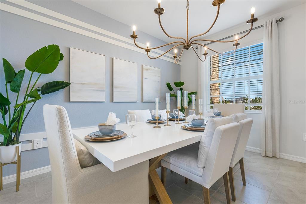 A dining room features a white table, upholstered chairs, a chandelier, and wall art — 13560 TURNLEAF BOULEVARD, PUNTA GORDA, FL