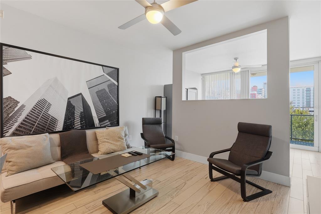 A living room features a sofa, two chairs, a glass coffee table, and a wall cutout — 111 N 12TH STREET UNIT 1310, TAMPA, FL