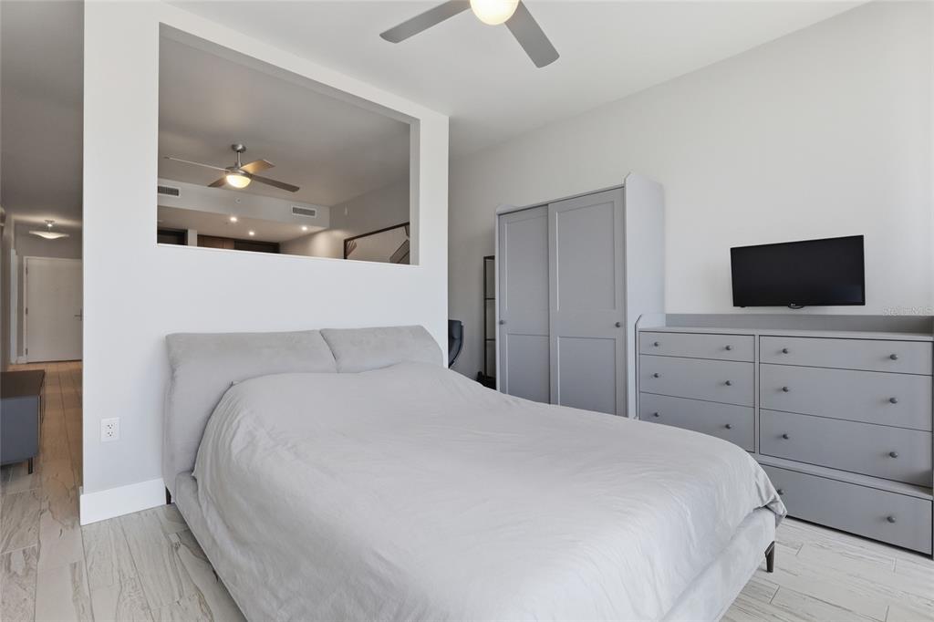A bedroom features a gray bed, matching wardrobe and dresser, and a large wall cutout — 111 N 12TH STREET UNIT 1310, TAMPA, FL