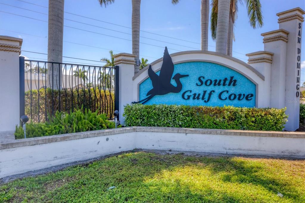 A sign for South Gulf Cove stands in front of a hedge and palm trees — 13305 BLAKE DRIVE, PORT CHARLOTTE, FL