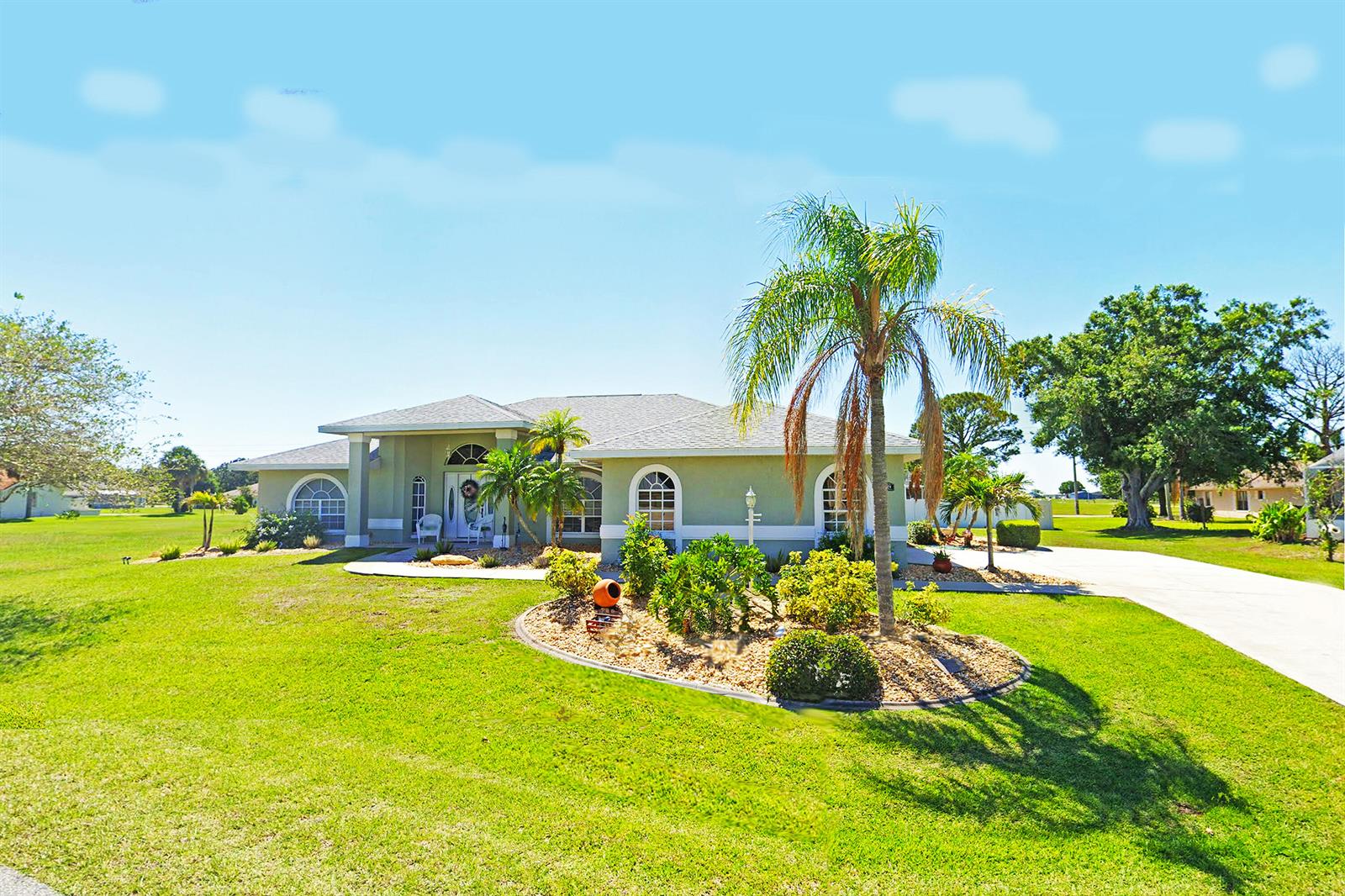 A single-story house with a light green exterior, a palm tree, and a landscaped front yard — 424 Holly Drive, Sebring FL 33876, SEBRING, FL