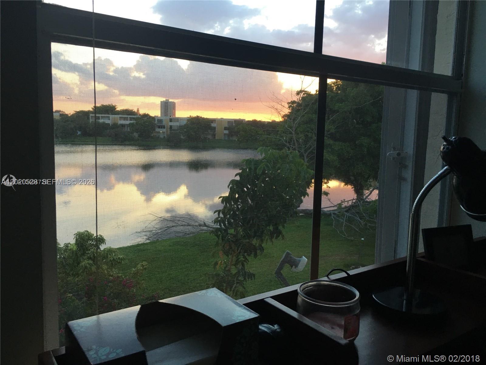 A view of a lake and sunset through a window from a desk area — 9167 Fontainebleau Blvd # 3, Miami FL 33172, MIAMI, FL