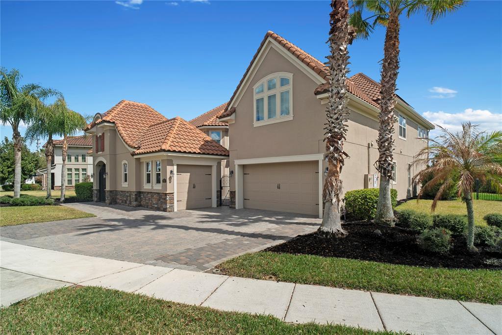 A two-story house with a tile roof, stone accents, and a paved driveway — 7560 BLUE QUAIL LANE, ORLANDO, FL