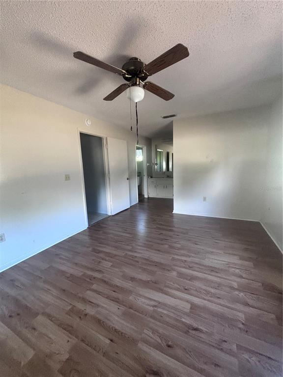 A bedroom with light wood-look flooring, white walls, and a ceiling fan — 8947 SW 108TH PLACE, OCALA, FL