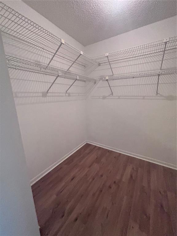 A walk-in closet with white wire shelving and wood-look laminate flooring — 8947 SW 108TH PLACE, OCALA, FL