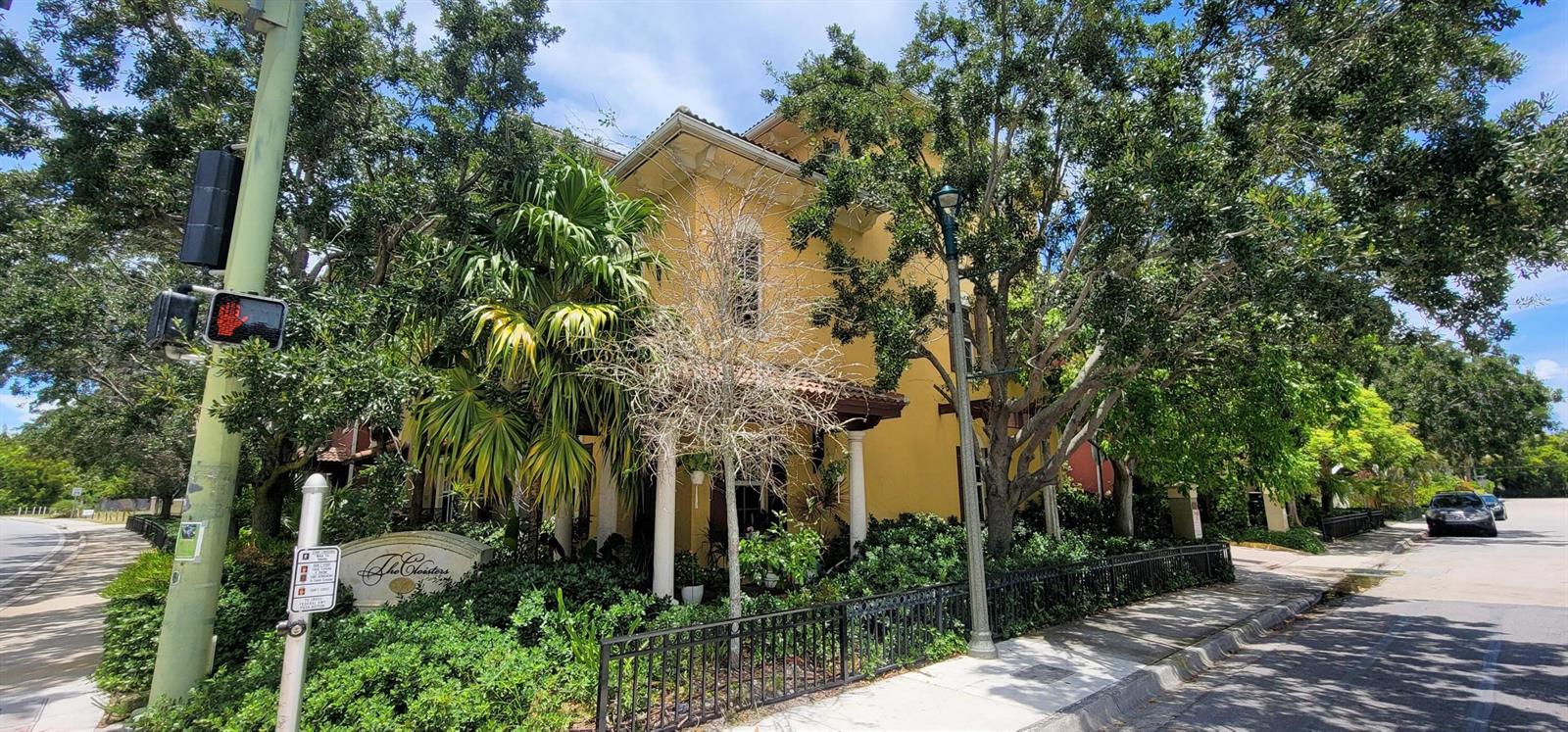 A yellow multi-story building sits behind a black metal fence with lush surrounding trees — 530 S Federal Highway # 8, FL 33460, FL