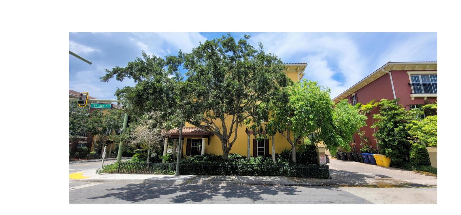 A yellow building with a tile roof stands behind a large tree and black fence — 530 S Federal Highway # 8, FL 33460, FL