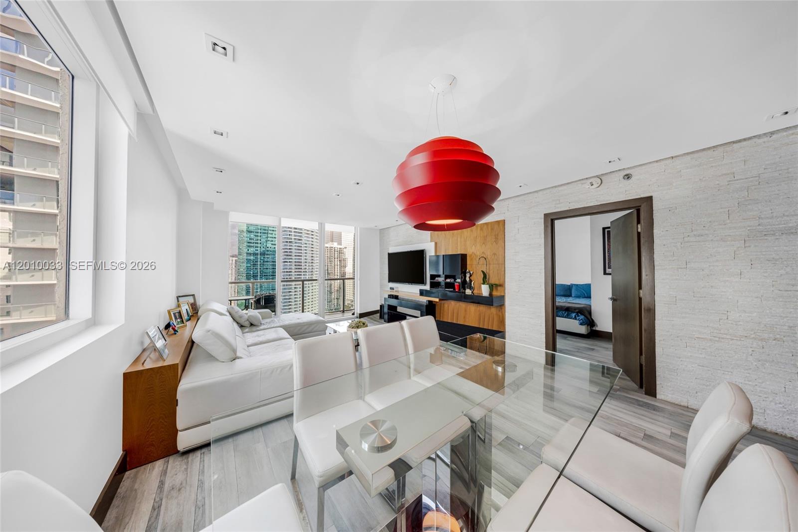 A modern living and dining area features a red pendant light and city views — 500 Brickell Ave # 3707, Miami FL 33131, MIAMI, FL