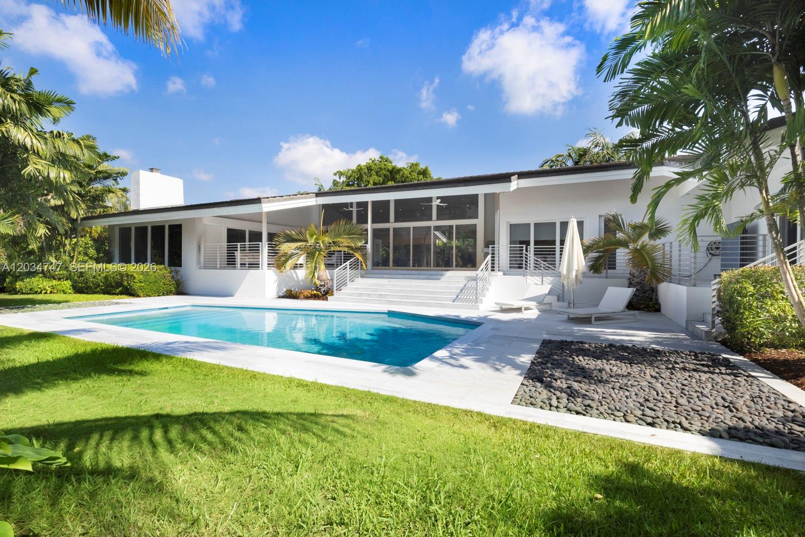 A modern white house with a swimming pool, patio, and palm trees in the backyard — 5780 Las Palmas Dr, Coral Gables FL 33156, CORAL GABLES, FL
