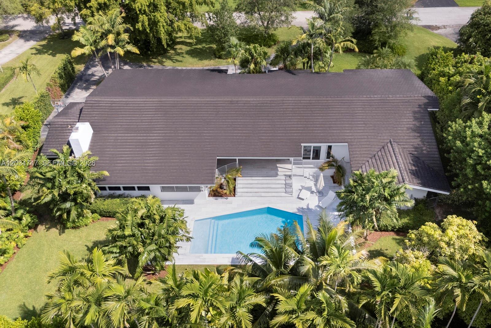 An aerial view shows a house with a dark roof, a swimming pool, and palm trees — 5780 Las Palmas Dr, Coral Gables FL 33156, CORAL GABLES, FL