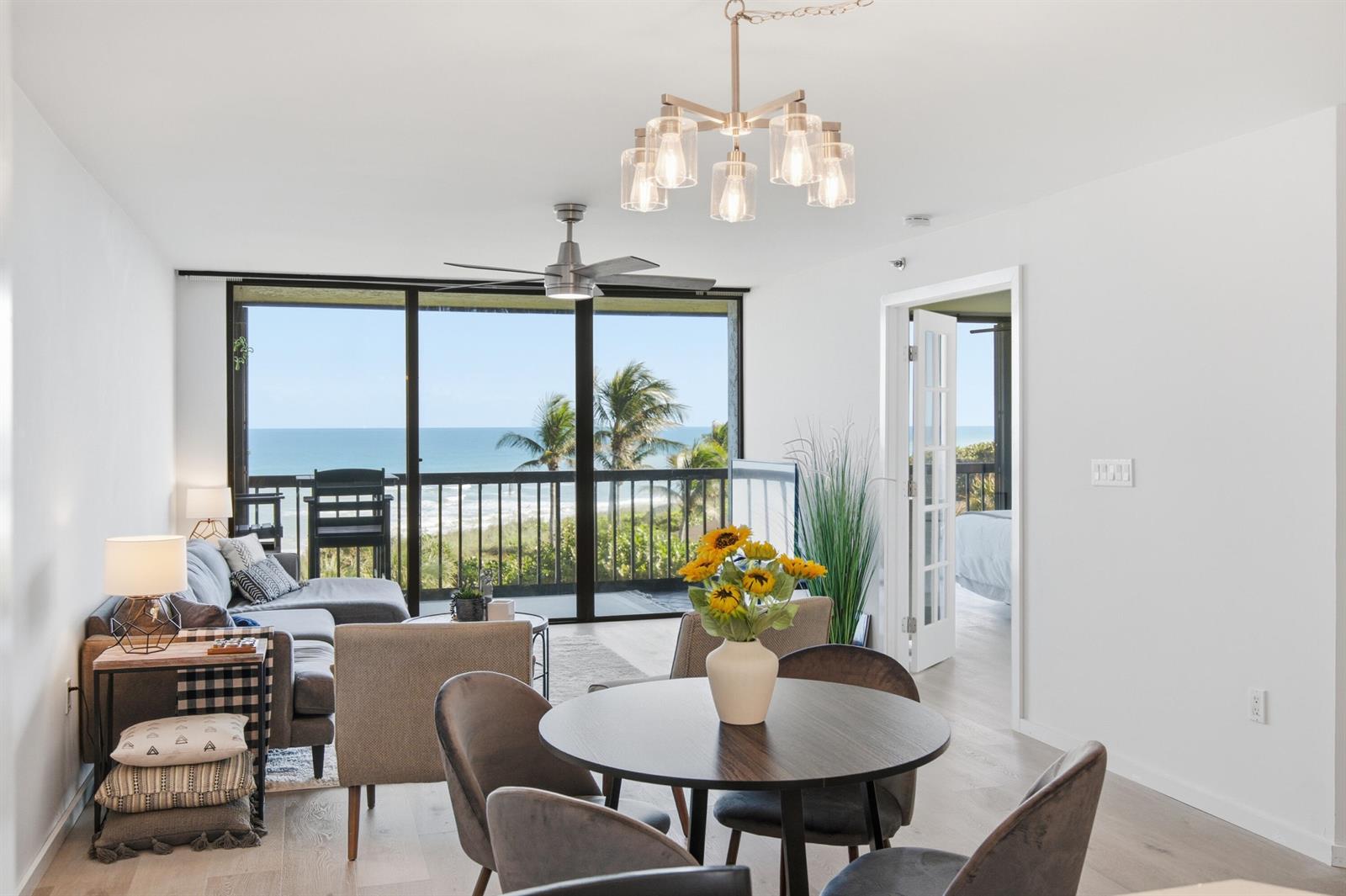 A living and dining area features a view of the ocean through large sliding doors — 8880 S Ocean Drive # 409, Jensen Beach FL 34957, JENSEN BEACH, FL
