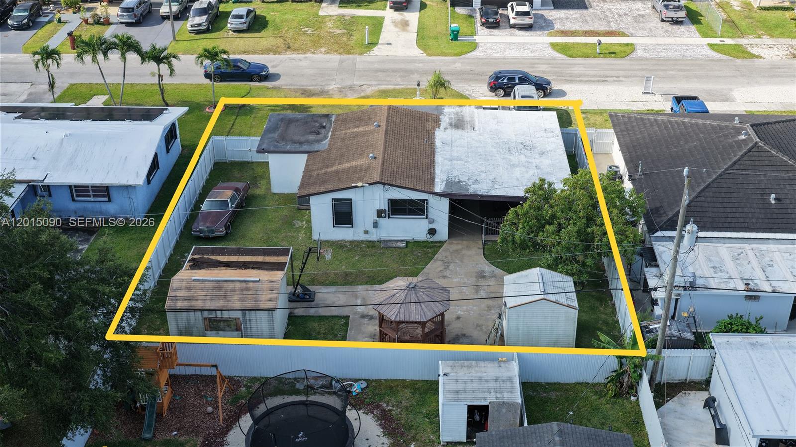 An aerial view shows a single-story house with a fenced yard, sheds, and gazebo — 10955 SW 217th Ter, Miami FL 33170, MIAMI, FL