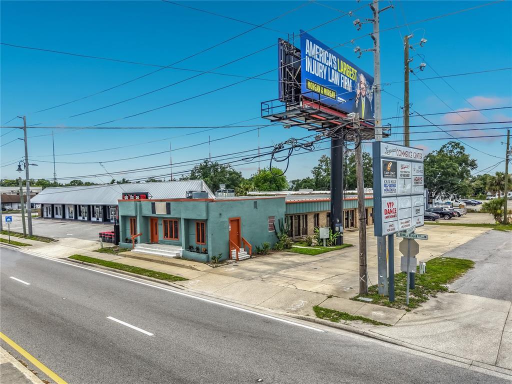 An aerial view shows a commercial area with buildings, a billboard, and a multi-lane road — 180 S RONALD REAGAN BOULEVARD, LONGWOOD, FL