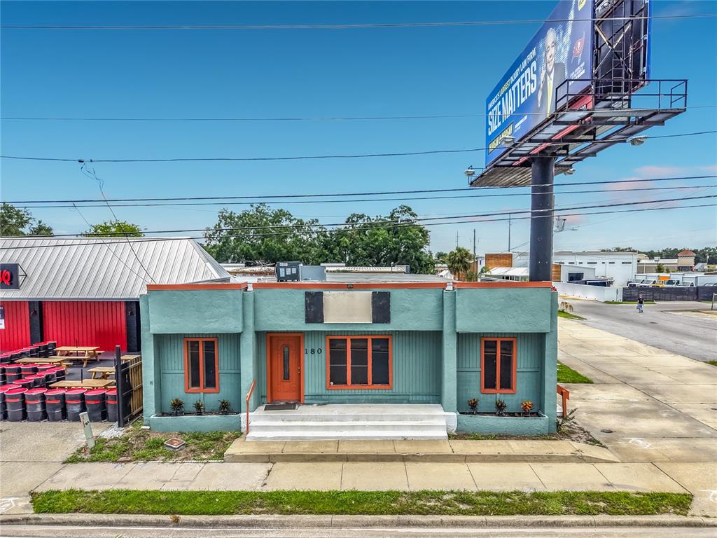 A single-story brick commercial building with a metal roof and an adjacent billboard — 180 S RONALD REAGAN BOULEVARD, LONGWOOD, FL