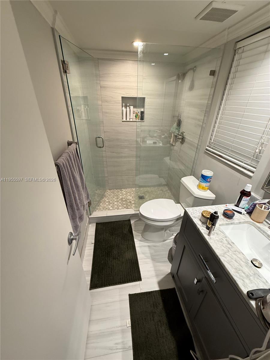 This bathroom features a glass-enclosed shower, a vanity with a stone countertop, and tile flooring — 7765 SW 86th St # 112, Miami FL 33143, MIAMI, FL