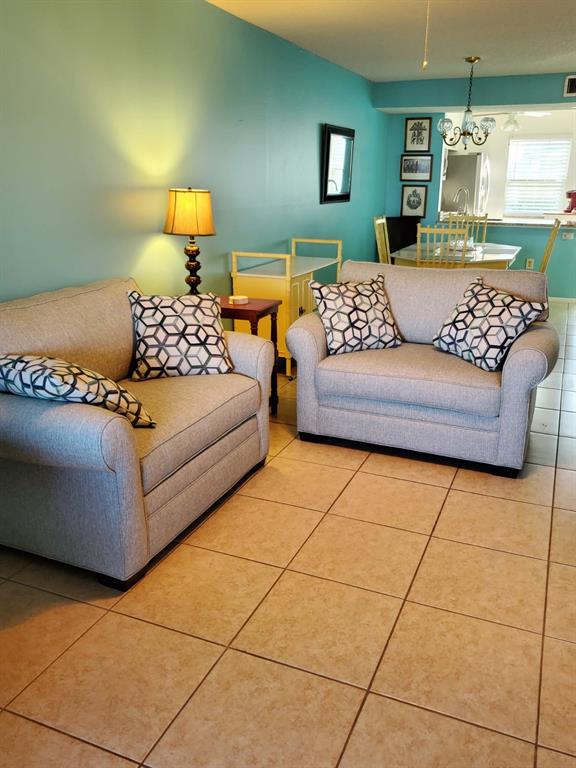 Two gray upholstered chairs with patterned pillows sit on a tiled floor in a room — 11135 CARRIAGE HILL DRIVE UNIT 3, PORT RICHEY, FL