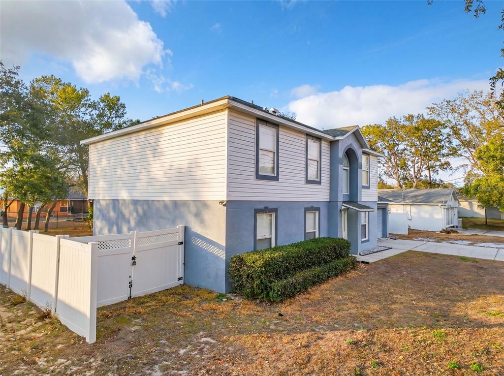 A two-story house with white siding and a blue stucco lower level exterior — 3181 DELTONA BOULEVARD, SPRING HILL, FL