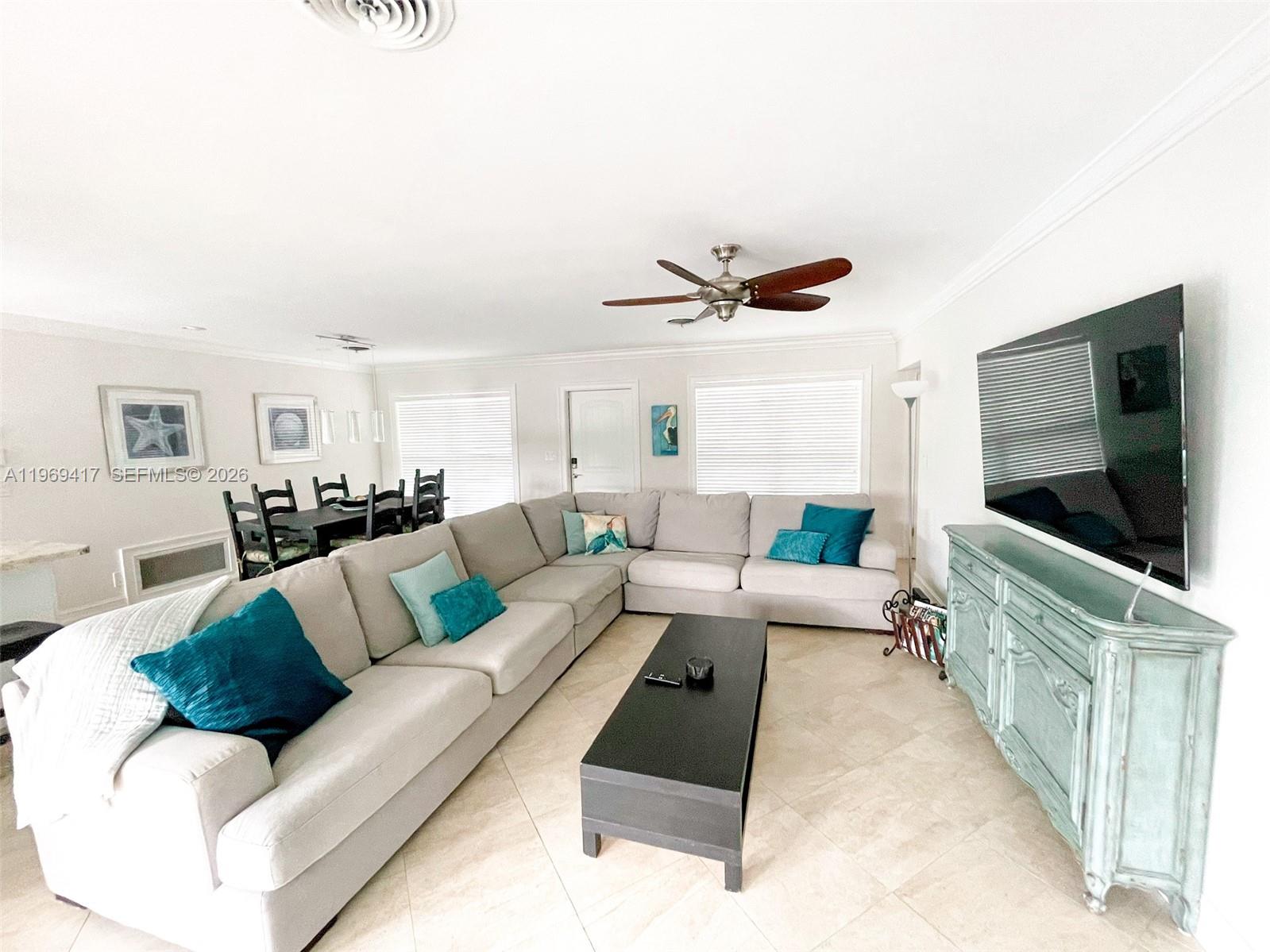 A living room features a large sectional sofa, a black coffee table, and a television — 2932 NE 36th St, Lighthouse Point FL 33064, LIGHTHOUSE POINT, FL