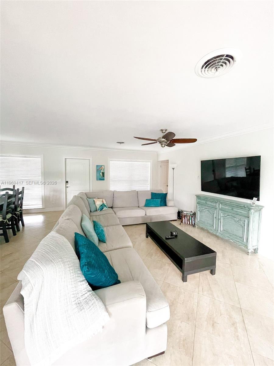 A living room features a large sectional sofa, a black coffee table, and a television — 2932 NE 36th St, Lighthouse Point FL 33064, LIGHTHOUSE POINT, FL