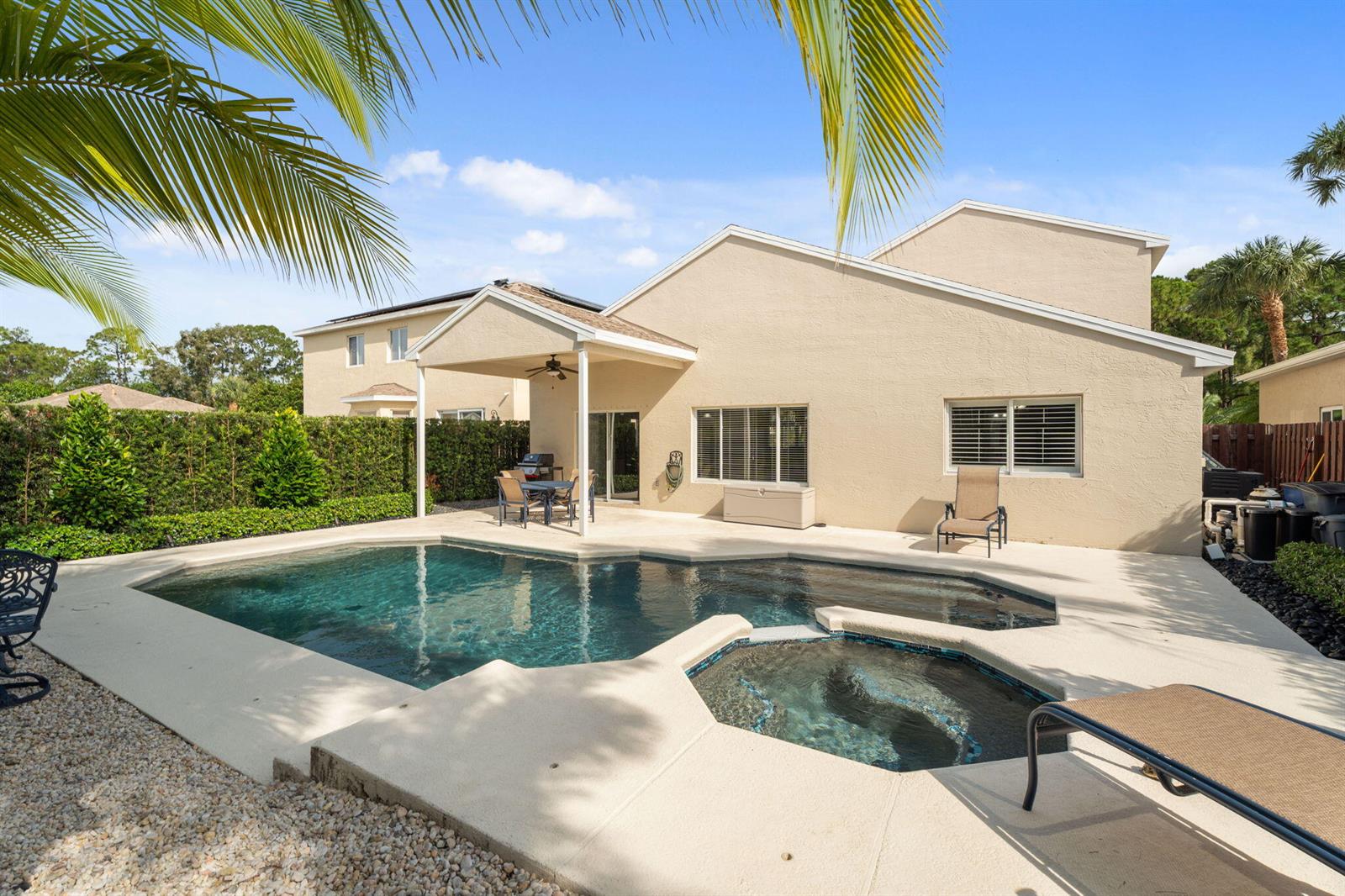 A backyard features a swimming pool, a hot tub, and a covered patio area — 4620 SE Winter Haven Court, Stuart FL 34997, STUART, FL