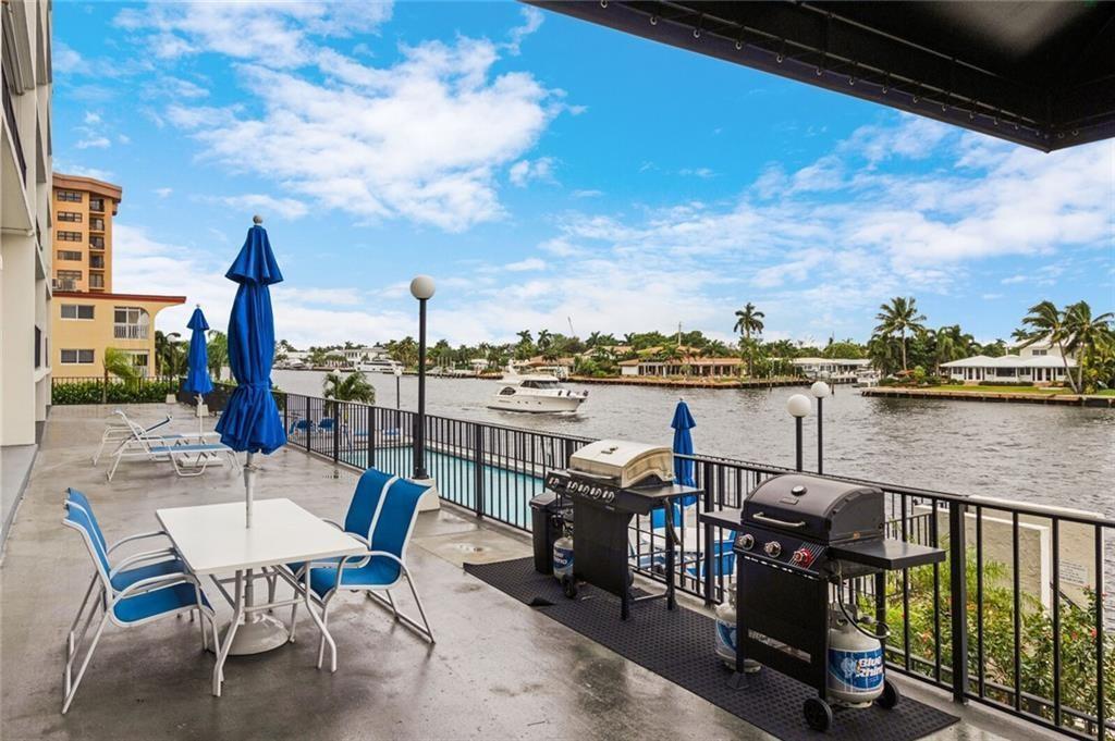 A waterfront patio features outdoor dining furniture, two gas grills, and a swimming pool — 521 N Riverside Drive # 602, Pompano Beach FL 33062, POMPANO BEACH, FL
