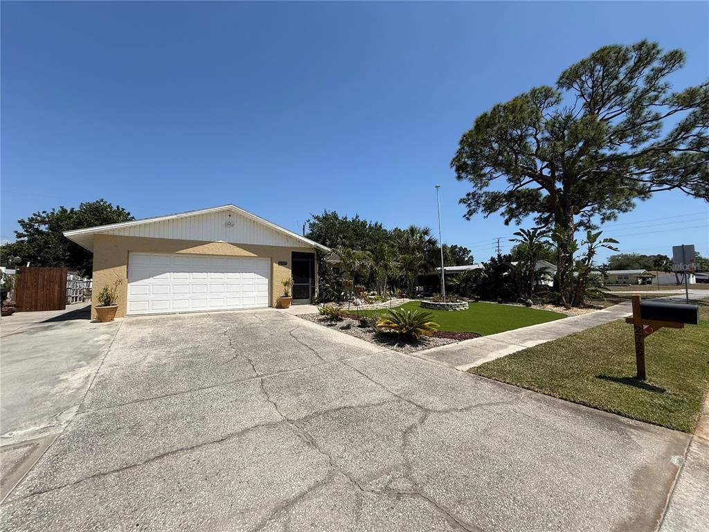 A single-story house with a white garage door, concrete driveway, and a manicured front lawn — 2729 NODOSA DRIVE, SARASOTA, FL