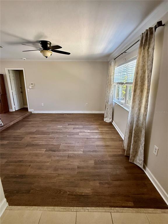An empty room features wood-look flooring, a ceiling fan, and a window with curtains — 2729 NODOSA DRIVE, SARASOTA, FL