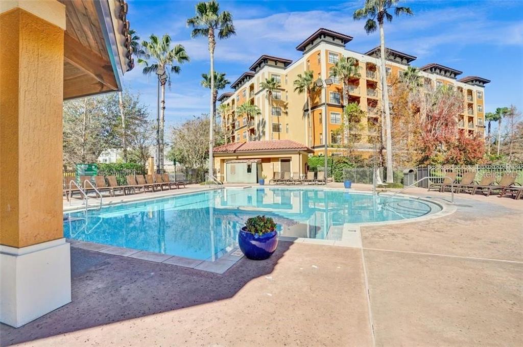 A swimming pool with lounge chairs sits in front of a multi-story apartment building — 12527 FLORIDAYS RESORT DRIVE UNIT 512E, ORLANDO, FL