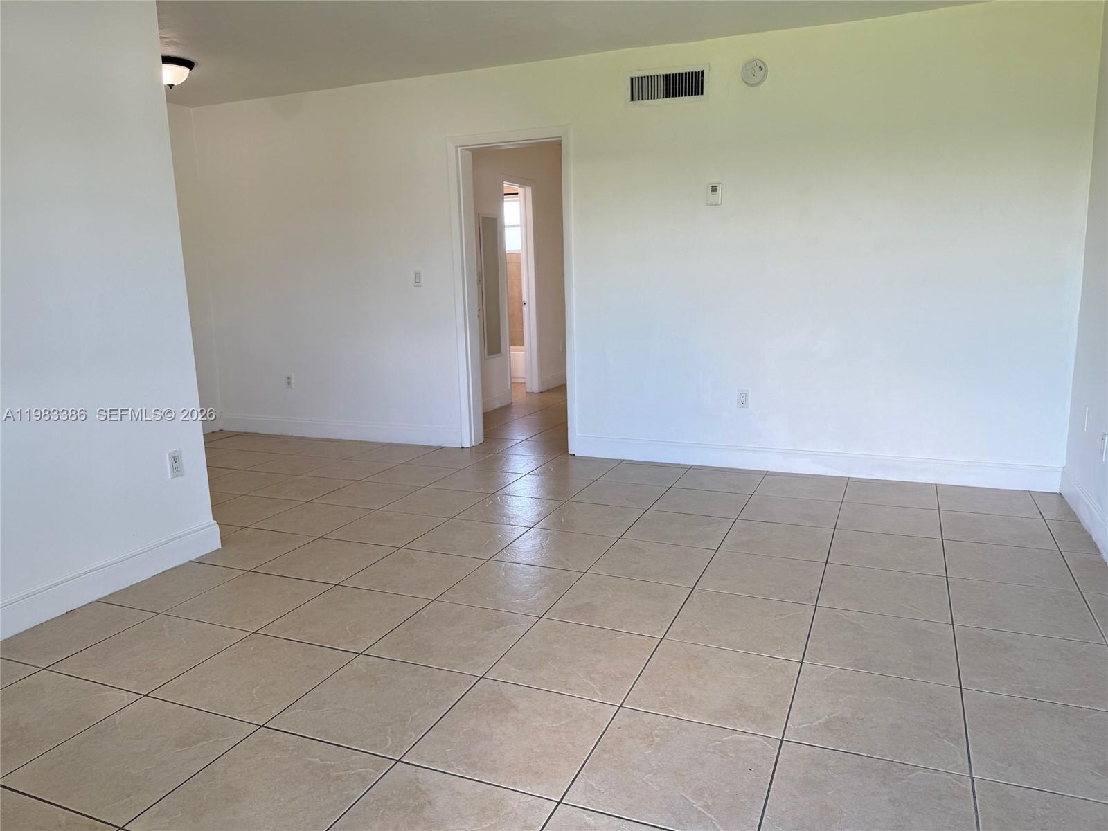 An empty room features white walls, beige tile flooring, and a doorway leading to another room — 4300 SW 67th Ave # 38, Miami FL 33155, MIAMI, FL