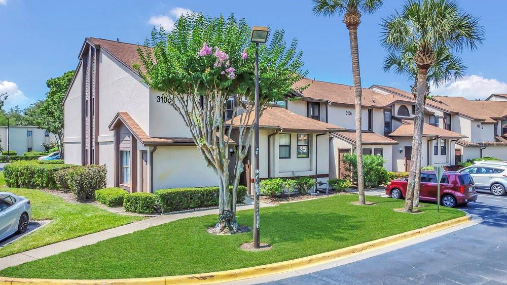 A multi-unit residential building with a manicured lawn, palm trees, and a parking lot — 3106 S SEMORAN BOULEVARD UNIT P-2, ORLANDO, FL