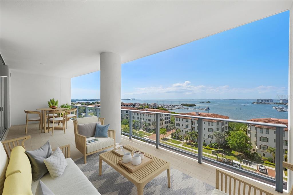 A furnished balcony overlooks a body of water with a marina and residential buildings — 5713 BOWEN DANIEL DRIVE UNIT 903, TAMPA, FL