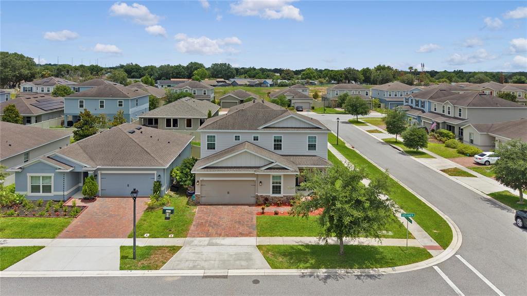A two-story suburban house with a tan stucco exterior, gray siding, and a paved driveway — 536 AFFIRMED WAY, DAVENPORT, FL